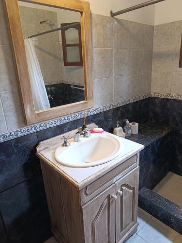 a bathroom with a sink and a mirror at Comfortable house in La Falda in La Falda