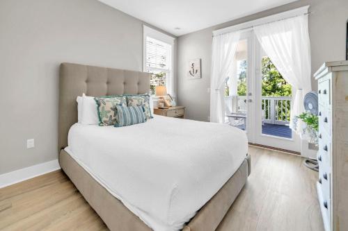 a bedroom with a large white bed with a window at Beachful Bliss in Santa Rosa Beach