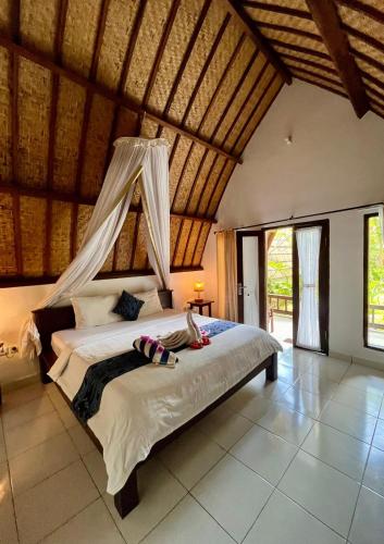 a bedroom with a bed with a mosquito net at Follow The Rabbit Bungalow in Gili Islands
