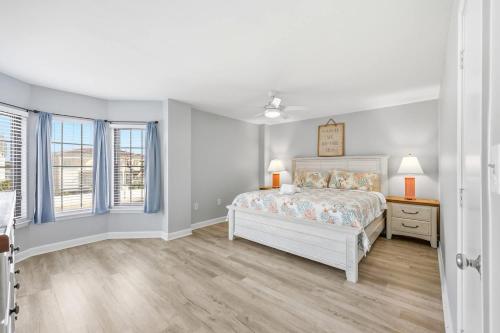 a white bedroom with a bed and a window at Sandy Bits Oceanfront Premium Condo with Pool in Myrtle Beach