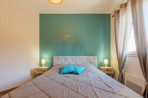 a bedroom with a bed with blue walls and two lamps at Villa Lisa in Balazuc