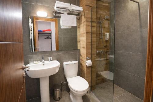 a bathroom with a toilet and a sink and a shower at Hilltop Kazbegi in Kazbegi