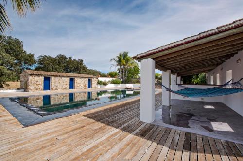 a wooden deck with a hammock on a house at Herdade dos Alfanges "THE BARN" in Viana do Alentejo