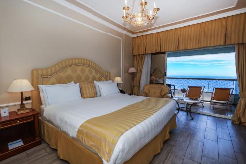 a hotel room with a bed and a large window at Grand Hotel Del Mare Resort & Spa in Bordighera