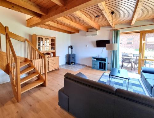 a living room with a couch and a staircase at Haus 16 im Natur Ferienpark, Natur, Abenteuer und Entspannung für unvergessliche Urlaubstage in Nieheim