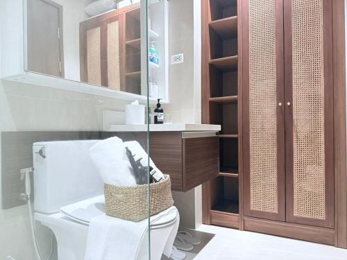 a bathroom with a toilet and a sink and a mirror at Tambuli Ocean View Luxe Studios, Mactan Seaside Residences in Lapu Lapu City