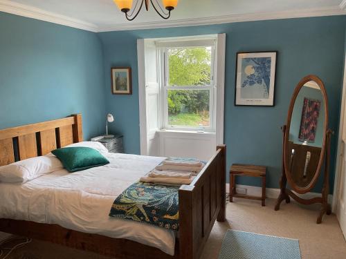 a bedroom with a bed and a window and a mirror at Mansefield Rooms in Lockerbie