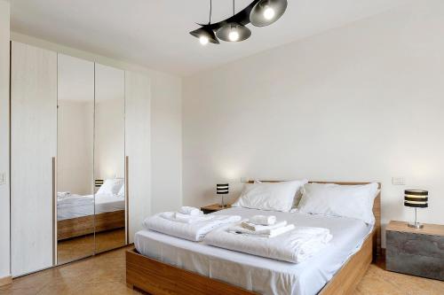 a bedroom with a bed with white sheets and a mirror at Casa Alessandra in Torri del Benaco