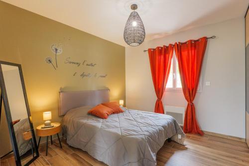 a bedroom with a bed with orange pillows on it at Villa Flora in Balazuc