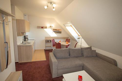 a living room with a couch and a kitchen at Ferienwohnung Köhler in Glowe