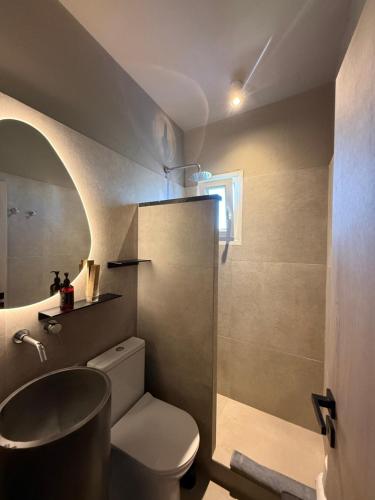 a bathroom with a toilet and a sink and a mirror at Mellow Paros in Parikia