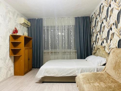 a small bedroom with a bed and a couch at Comfort Home Gogolya in Karagandy