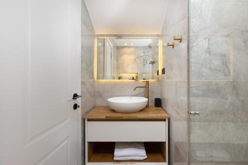 a bathroom with a sink and a glass shower at Coral suites Boutique in Eilat