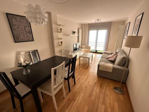 a dining room and living room with a table and a couch at Playa América 2C by YBH in Nigrán