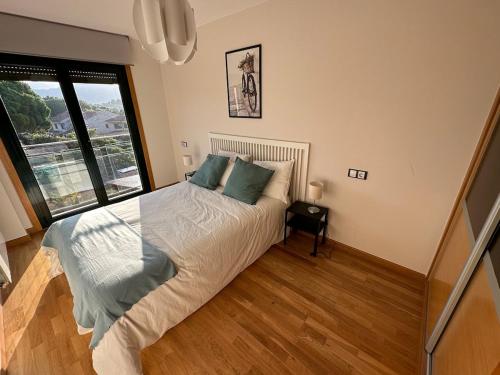 a bedroom with a bed and a large window at Playa América 2C by YBH in Nigrán