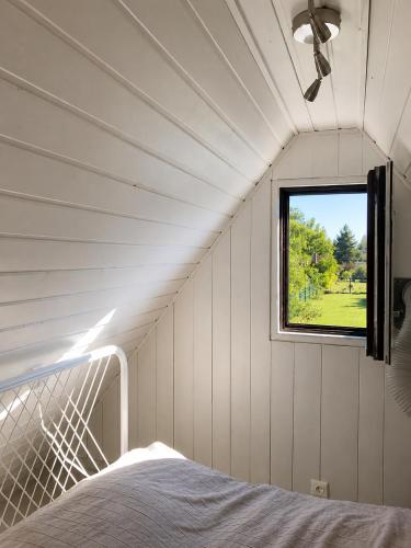 a white room with a bed and a window at DIÓFA APARTMAN in Pilismarót