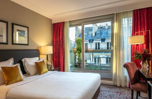 a hotel room with a bed and a large window at Warwick Paris Champs-Elysées in Paris
