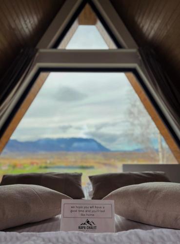 a bed with a window with a sign on it at Kapa Chalet Bran in Sohodol