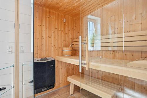 a sauna with wood paneling and a glass wall at Nordseeperle in Greetsiel