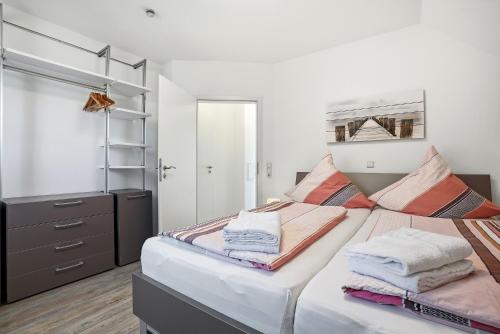 a bedroom with a bed with towels on it at Nordseeperle in Greetsiel