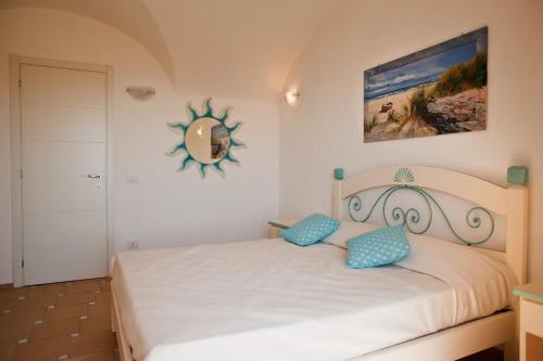 a bedroom with a bed with blue pillows and a mirror at Le Ville Le Saline in Palau