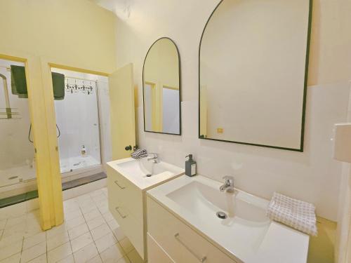a bathroom with two sinks and a mirror at Eden - Franklin 6 in Adelaide