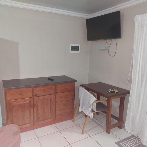 a room with a desk and a table and a television at 1atKruger Unit 2 in Mokopane