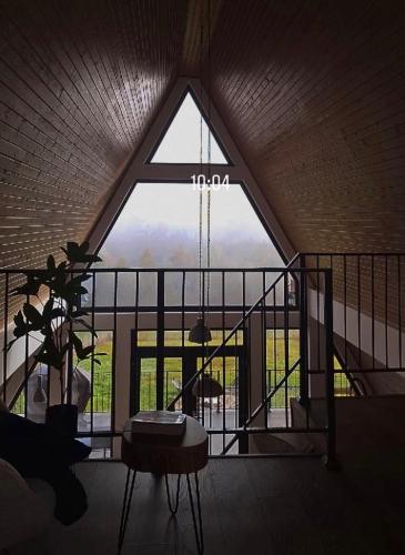 a room with a large window and a table at Kapa Chalet Bran in Sohodol