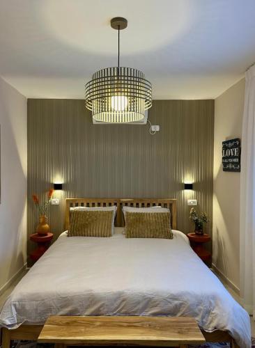 a bedroom with a large bed and a chandelier at זוג ידיים - סוויטה עם בריכה פרטית, סאונה וג'קוזי in H̱osen