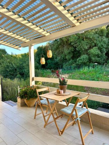a wooden table and chairs under a wooden pergola at זוג ידיים - סוויטה עם בריכה פרטית, סאונה וג'קוזי in H̱osen