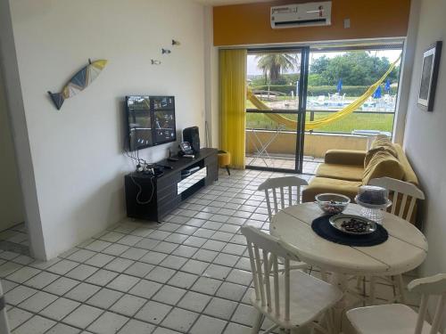 a living room with a table and a tv at GAVOA Beach FLAT in Água Boa