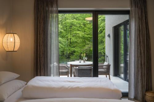 a bedroom with two beds and a balcony with a table at steiRerBLiCke - Gaberhö Gamlitz in Gamlitz