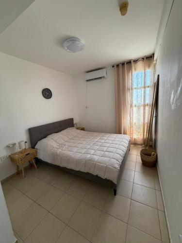 a bedroom with a bed in a room with a window at Room 805 in Eilat