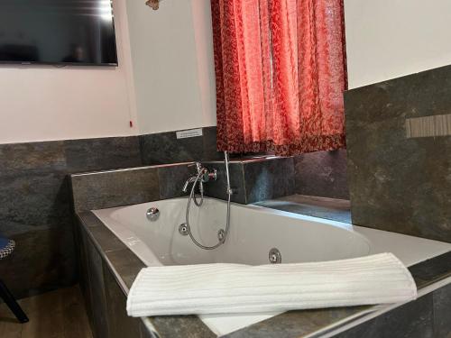 a bath tub in a bathroom with a red curtain at Poste Regie - Milan Guest House in Milan