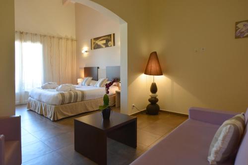 a hotel room with two beds and a couch at Hôtel A Madonetta in Bonifacio
