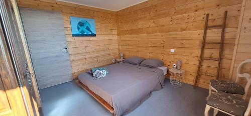 a bedroom with a bed in a wooden room at La Maison En Bois in Figeac