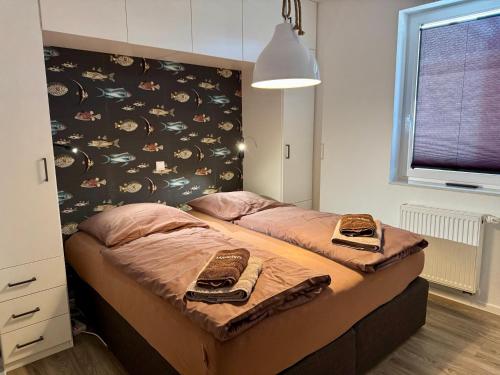 a bedroom with two beds and a wall with a window at Mariehus in Wangerooge