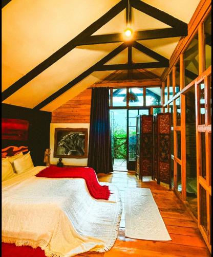 a bedroom with a bed and a large window at TheCabinsNanyuki in Nanyuki