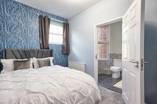 a blue bedroom with a bed and a toilet at Reeha's Hotel Apartments in Southend-on-Sea