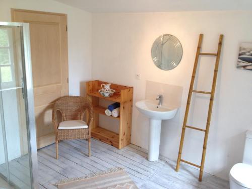 a bathroom with a sink and a mirror and a chair at Pion La Grange - cottage barn conversion in Castelnau-dʼAuzan