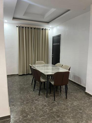 a conference room with a glass table and chairs at Kayus Place in Isaga-Abosule