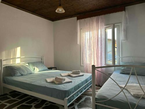 a bedroom with two beds with towels and a window at Casa de Palma in Asprovalta