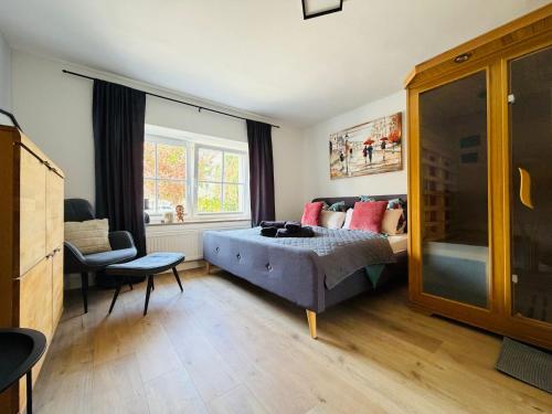 a bedroom with a bed and a chair and a window at Fewo Seestern in Neukieritzsch