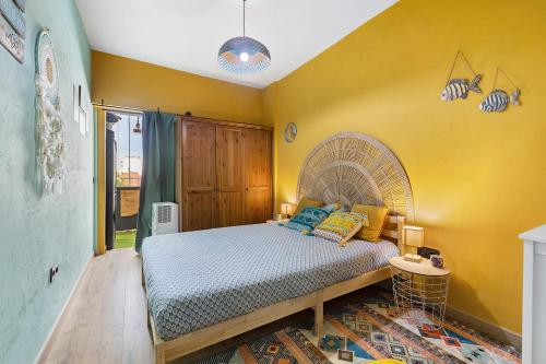 a bedroom with a bed and a yellow wall at Beach fun in Costa da Caparica