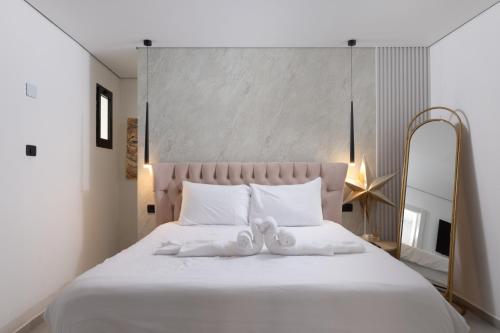 a bedroom with a white bed with a teddy bear on it at Coral suites Boutique in Eilat