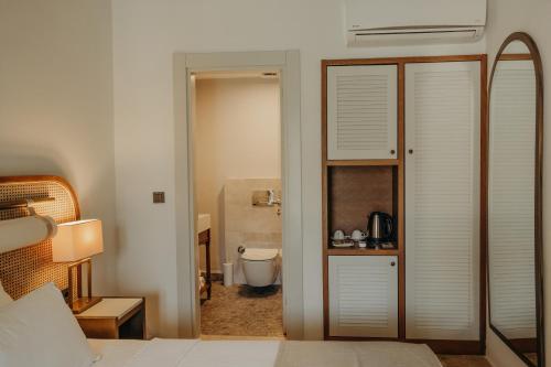 a bedroom with a door leading to a bathroom at Alaçatı Lotus Bahçe in Alaçatı