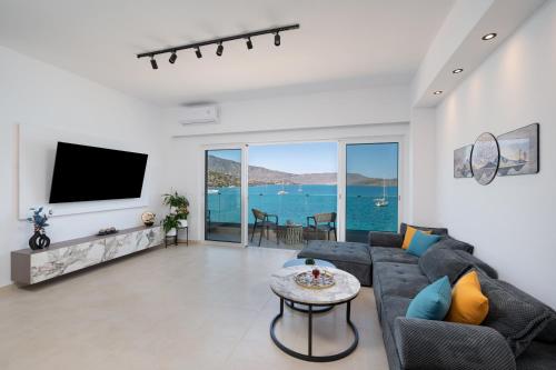 a living room with a couch and a tv at Blue Horizon Elounda in Elounda