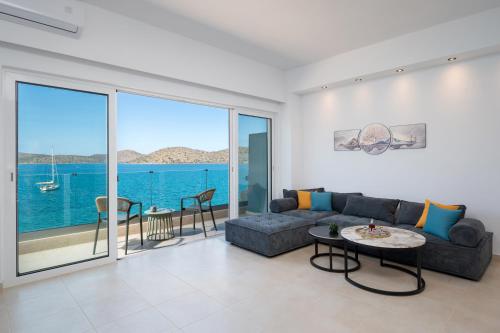 a living room with a couch and a table at Blue Horizon Elounda in Elounda