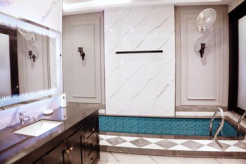 a bathroom with a sink and a large mirror at Summer Villa in Lahore