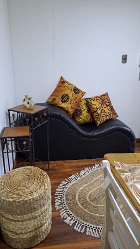 a black couch with pillows on it in a room at Central Zenteno en Punta Arenas in Punta Arenas